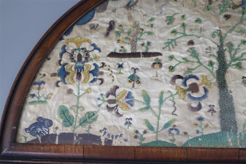 A late 17th century silk and bead work arched panel, width 22.5in. height 11.75in.